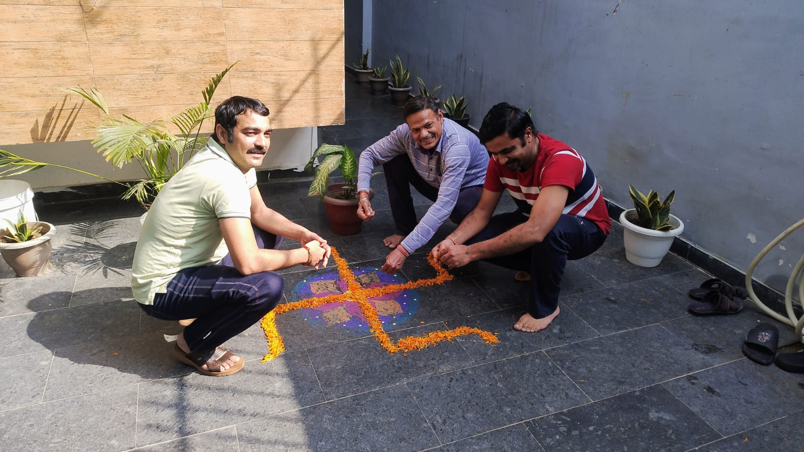 Three patients creating a floral rangoli at SimranShri during festival preparation
